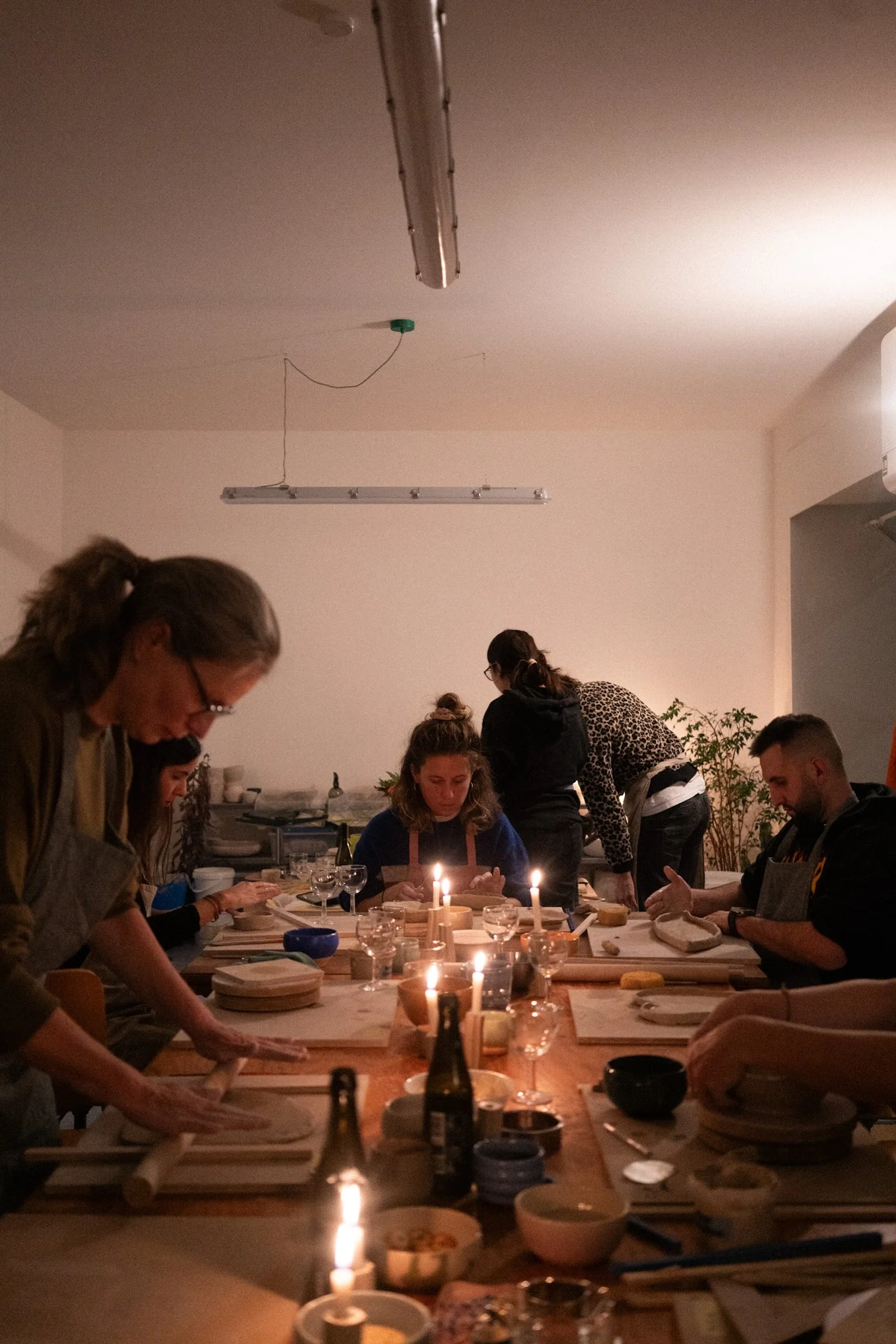 A relaxed evening pottery session around a shared studio table