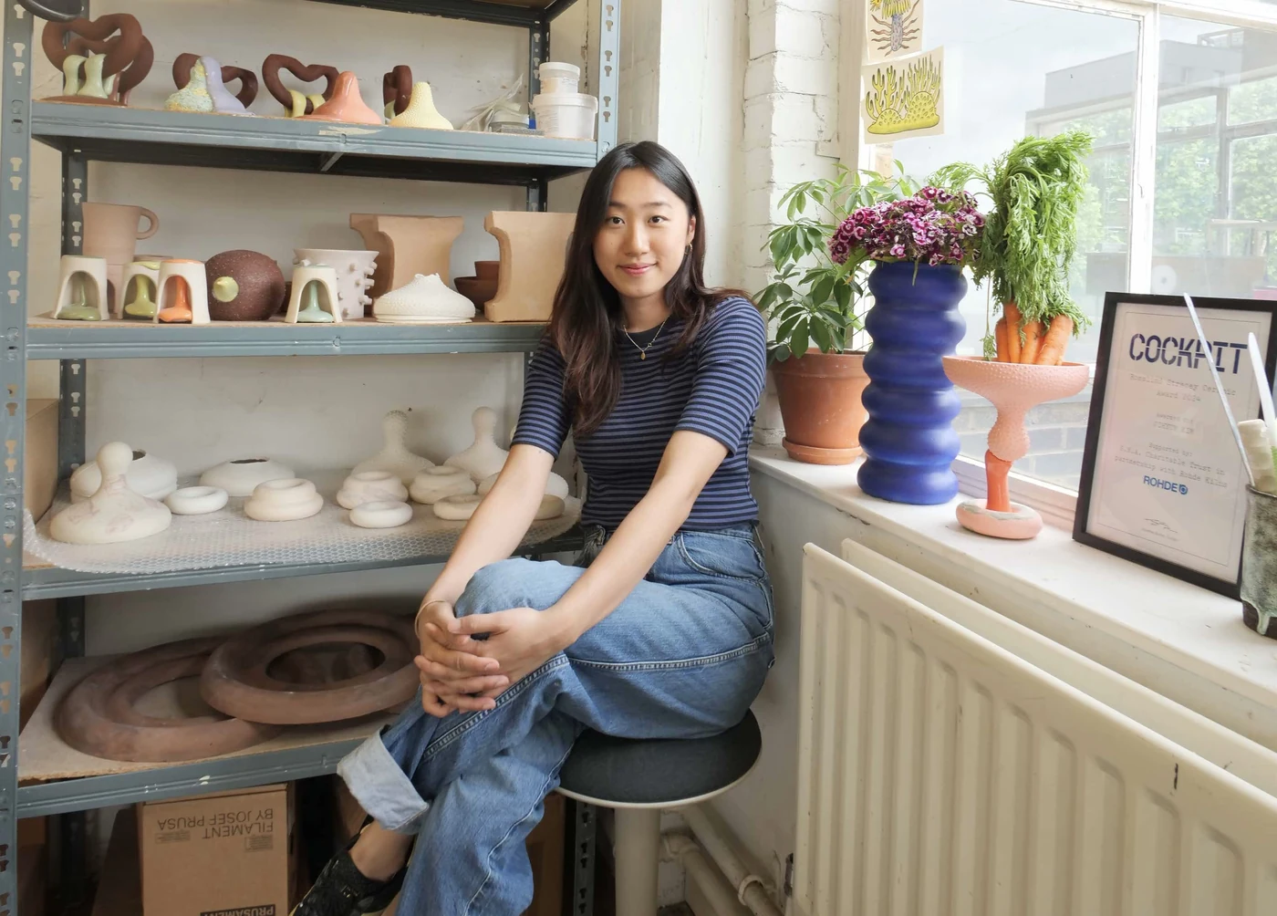 Jihyun Kim seated in her London studio surrounded by her ceramic work