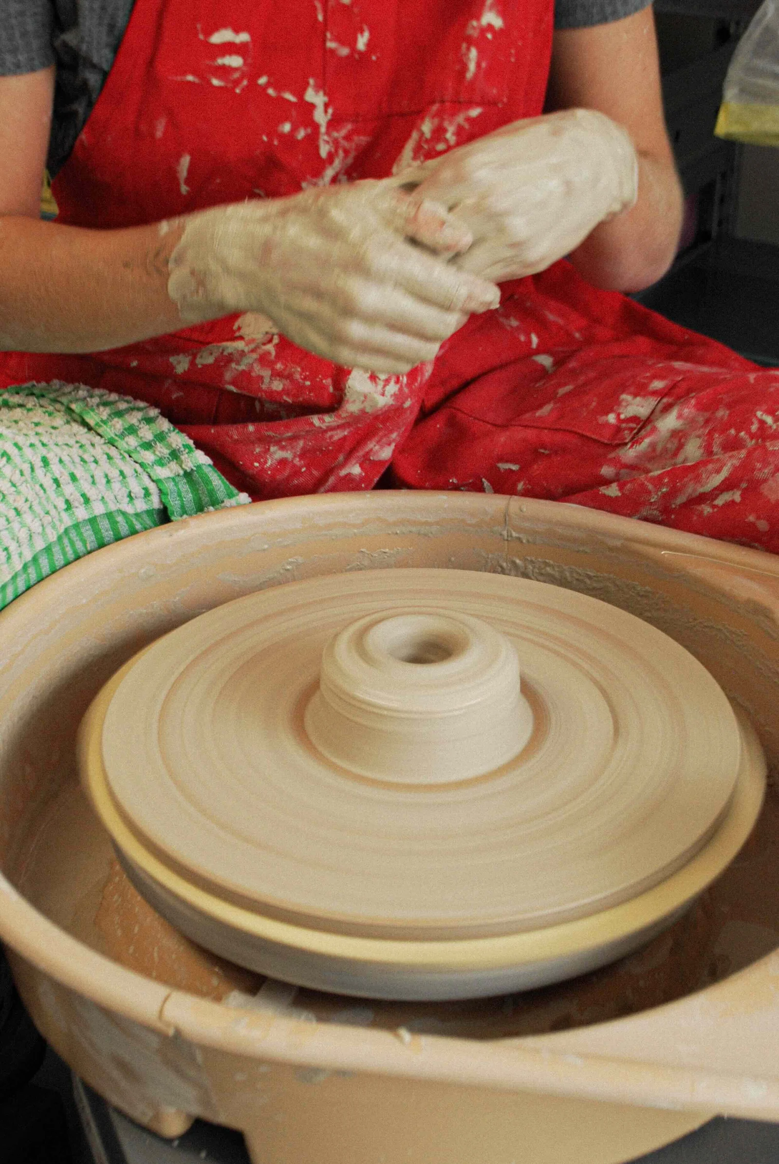 A potter centring clay on the wheel